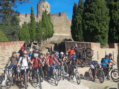 des jeunes sur des VTT devant un château